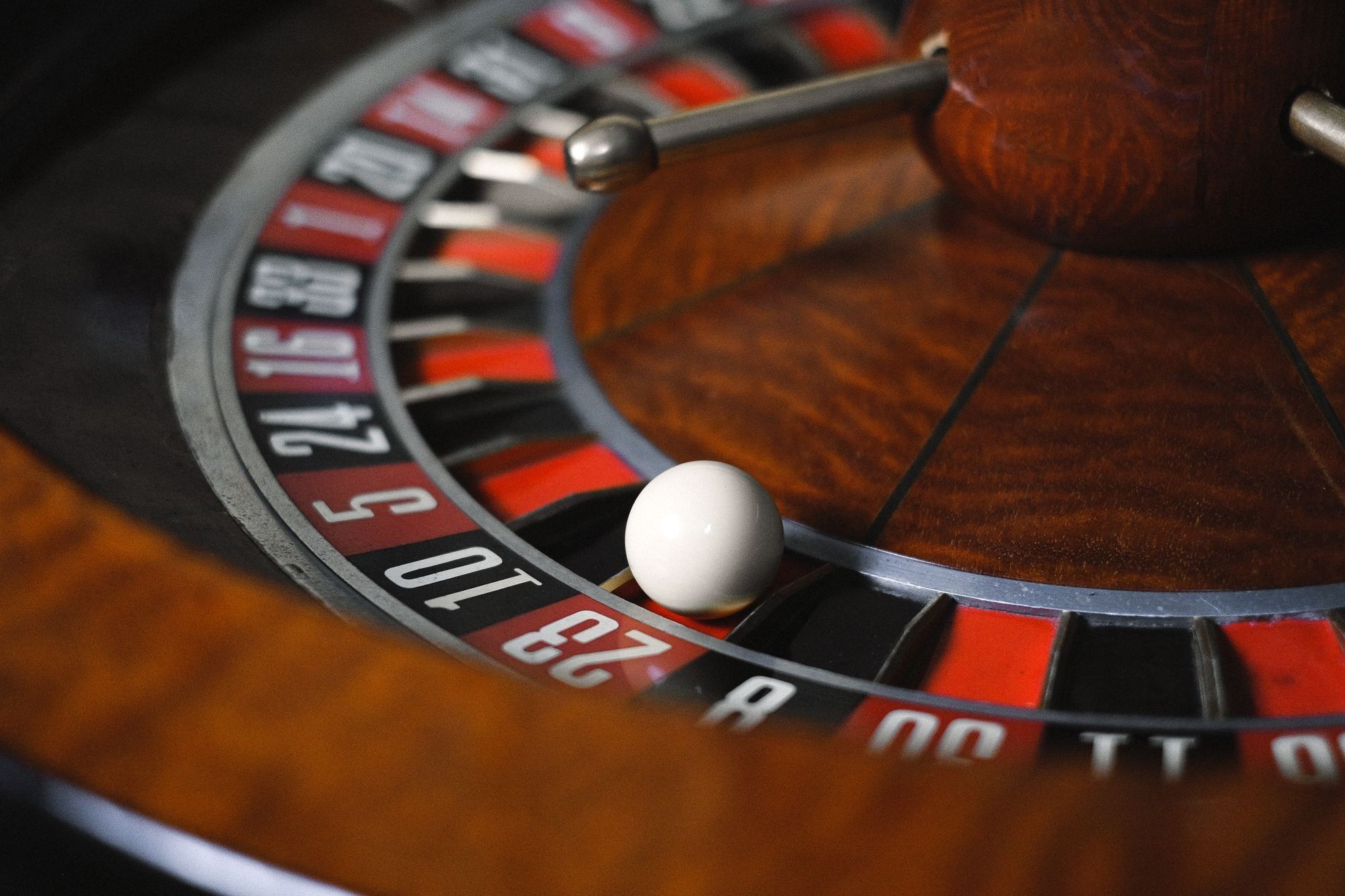 Close-up of a wooden roulette wheel with the white ball resting in a pocket